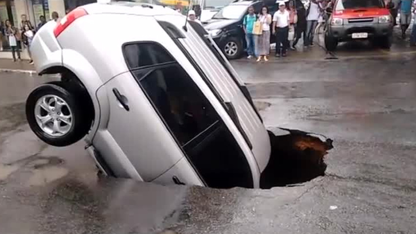 لحظة سقوط سيارة داخل حفرة عملاقة وسط الطريق  (فيديو)
