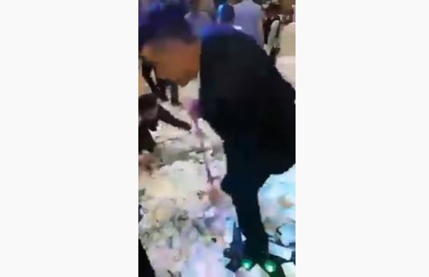 شاهد الفيديو/ الأموال تغطى أرضية قاعة أفراح في حفل زفاف